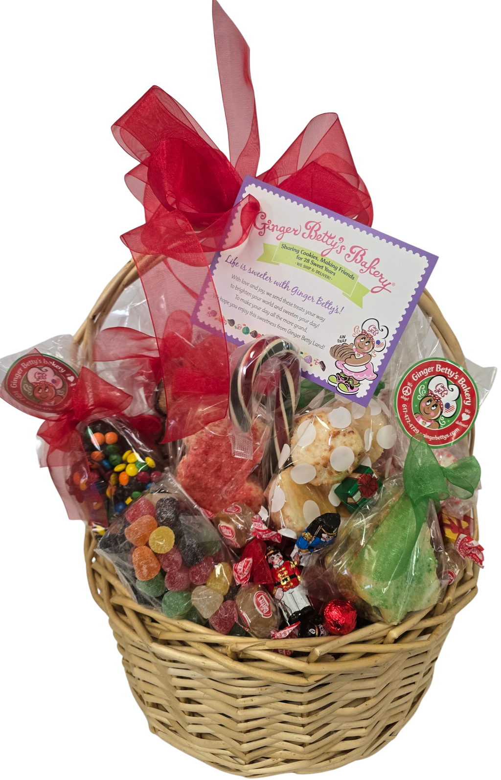 Wicker gift basket filled with colorful candies and a red ribbon on a white background
